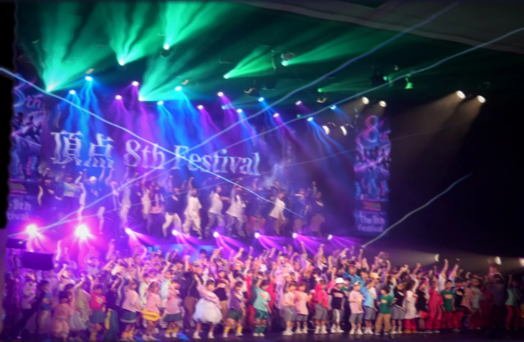第8回・2026年。LEDに『頂点 8th Festival』。緑と青の光の中の全員。